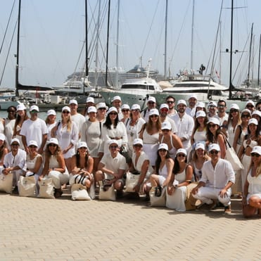 Gruppenfoto vor dem Katamaran im Hafen von Palma, alle Personen sind in weiß gekleidet und lachen in die Kamera