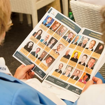 Ein Teilnehmer des Wirtschaftsforum NEU DENKEN studiert die Referentenliste