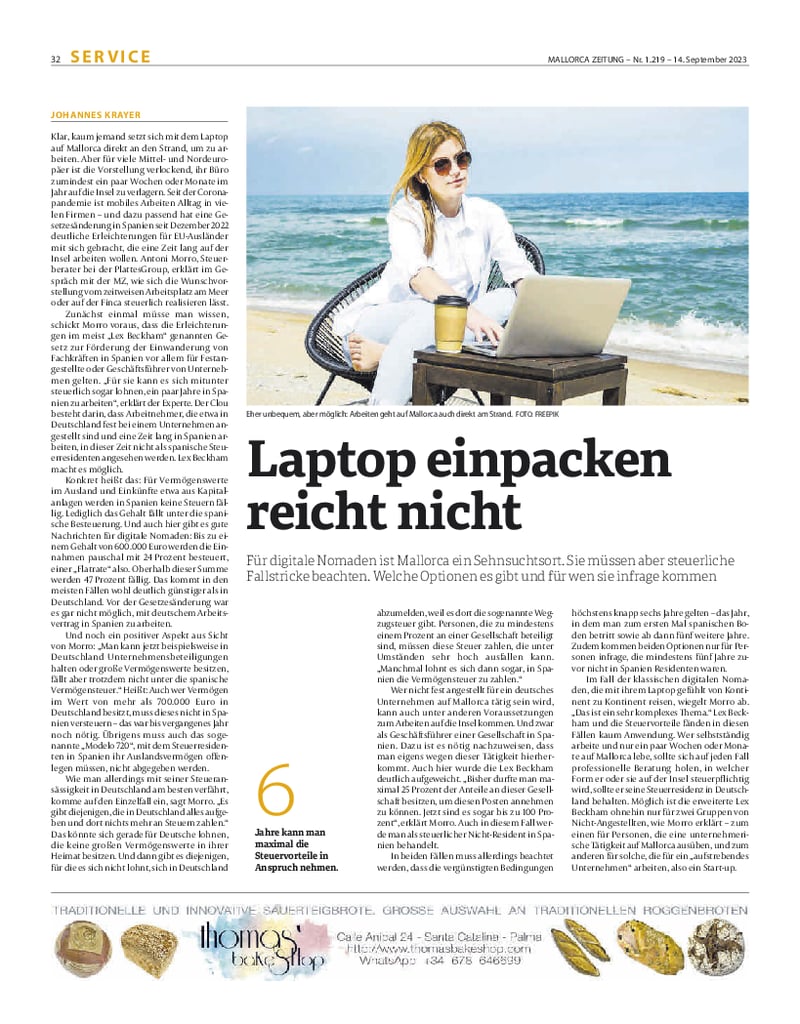Zeitungsartikel mit Foto von einer Frau am Laptop am Strand